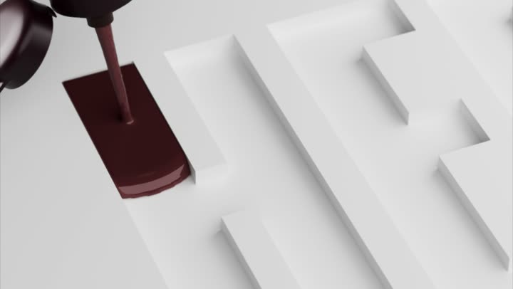 Chocolate pouring from a nozzle into the first letter.