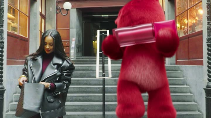 The bear walking down a flight of steps in a city street.
