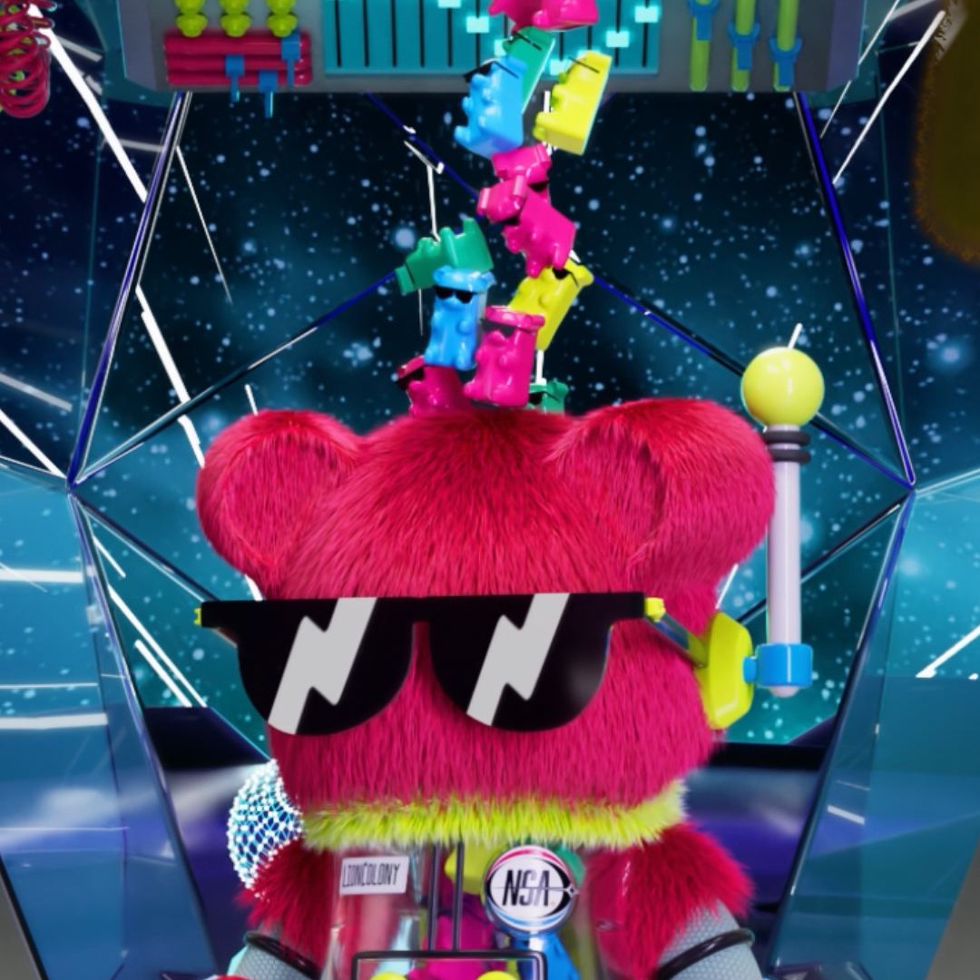A pink furred figure in the same sunglasses inside a mirrored chamber, coloured gummy figures falling from a chute above it against a starfield.