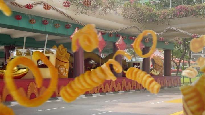 Curly fries scattered in the air over a festival gateway.